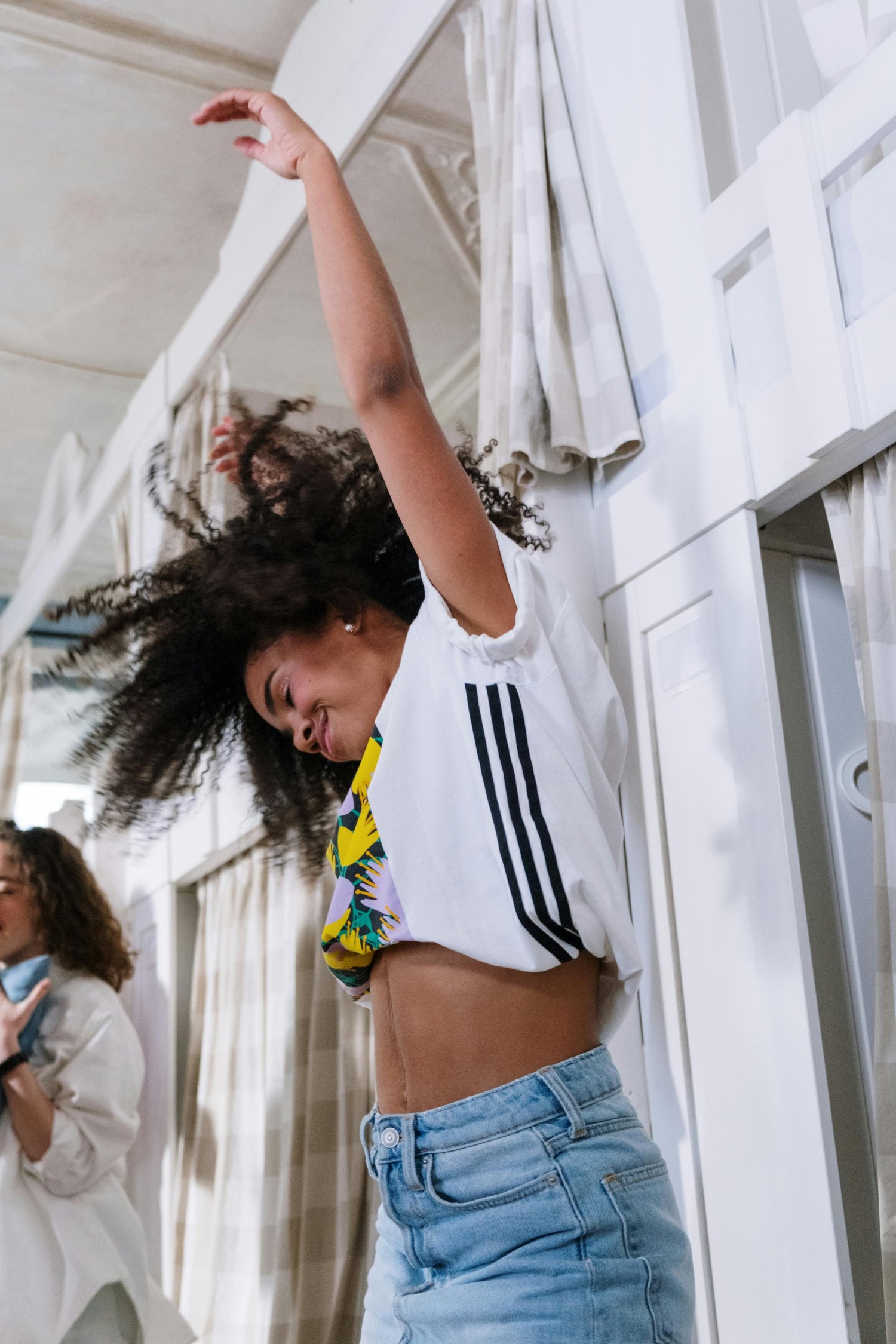 A young woman dancing with her eyes closed.